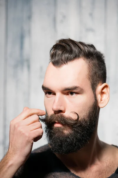 Портрет бородатого человека, скручивающего усы — стоковое фото