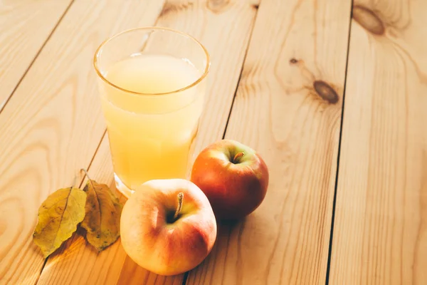 Frische Äpfel mit einem Glas Saft. Stockfoto