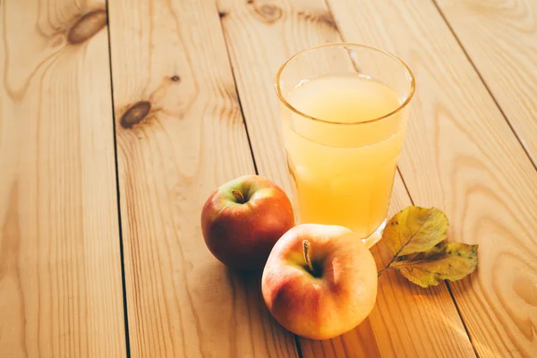 Frische Äpfel mit einem Glas Saft. Stockfoto