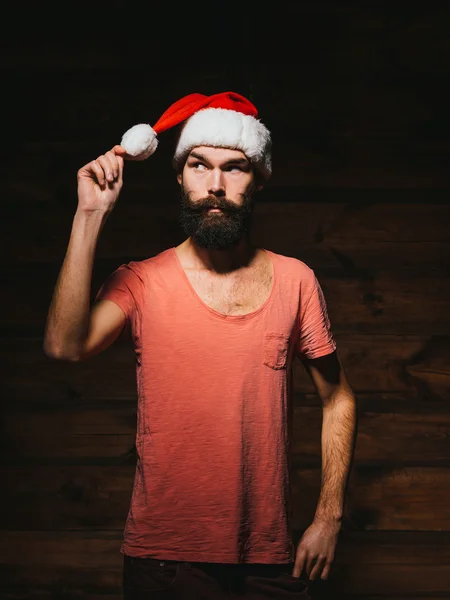Bärtiger Hipster mit großen Schnurrbärten im Weihnachtsmannhut. lizenzfreie Stockbilder