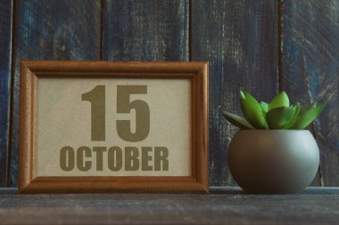 15 Ekim 'de. Ayın 15 'i, ahşap arka planda sulu bir çerçevenin yanında yılın günü konsepti olan sonbahar ayı..