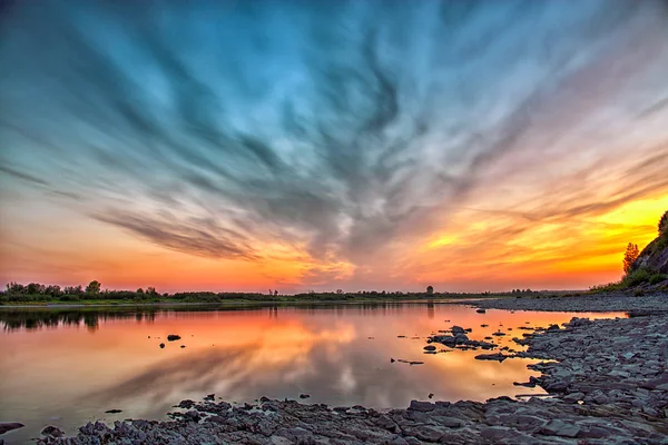 Uma bela noite de pôr do sol sobre um rio Fotos De Bancos De Imagens