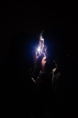 Bir çift aşık gece ışığa karşı öpüşür. Mavi ışık huzmeleri yüzlerin yanından geçer, parlak bir parıltı etkisi yaratır. Sahne ışıklarının altındaki karanlıkta yaşayan insanların siluetleri.