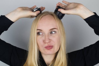 Kadın kameradaki iki lensi boynuz gibi takıyor. Oynuyor, oynaşıyor. Fotoğrafçının işi ve fotoğrafçılığa yaratıcı yaklaşımı.