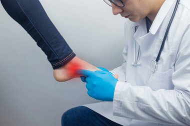 Bir ortopedi cerrahı bir kadının bacağını muayene eder. Ayak ağrısı, tendon burkulması, iltihap, düz taban, burs, fasiit. Ayak hastalığı tedavisi konsepti. Doktor muayene ediyor.