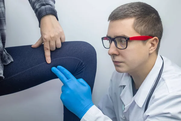 A woman suffers from pain in the inner thigh. The concept of treating a hip joint for trauma, myositis, impaired nerve endingsor osteoarthritis. The doctor examines