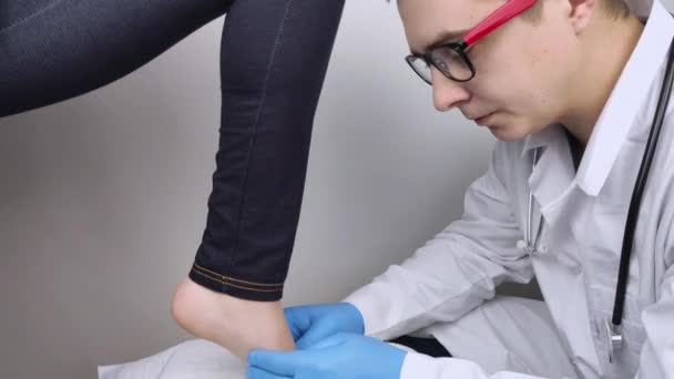 Ortopedický chirurg zkoumá ženskou nohu. Bolest nohou, vymknutí šlach, zánět, ploché nohy, bursitida, fasciitida. Myšlenka léčby onemocnění nohou. Lékař vyšetřuje