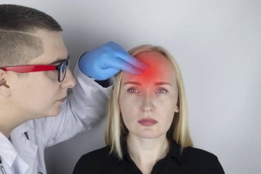 Bir kadın elleriyle başını tutuyor. Baş ağrısı, migren ve baş dönmesi. Stresten ya da aşırı çalışmaktan başım ağrıyor. Bir doktorun muayenesinde..