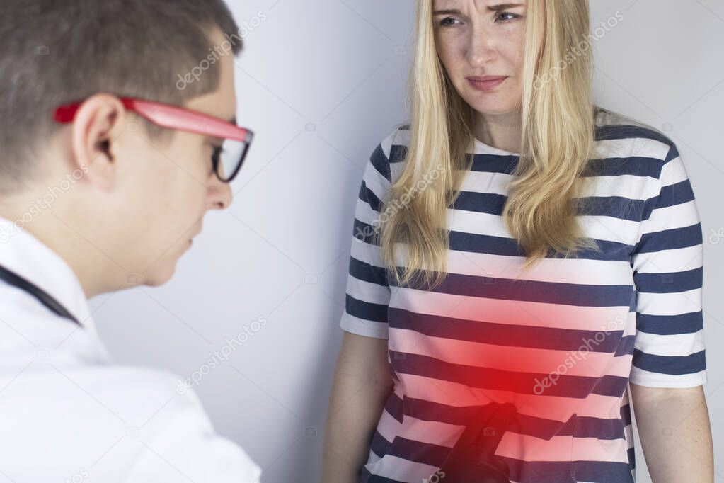 A woman holds on to his stomach. Pain in the abdominal cavity. The concept of diseases of the stomach and digestive system. The doctor will palpate to find out the source of the pain