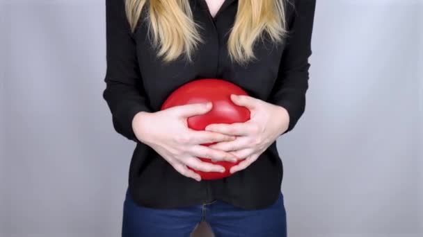 膨満感と鼓腸の概念 女性は腹部の近くに赤い風船を持っており これは膨満感を象徴している 腸管および消化器系 鼓腸と消化管の問題 — ストック動画