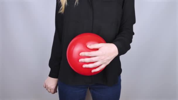 概念摄影 女人在他的腹部附近拿着一个红色的球 象征着浮肿和浮肿 她用针头扎破气球 把问题解决了 — 图库视频影像