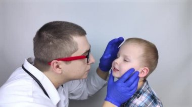 Otolarbilimci geniz geçidini inceliyor. Burunda acı verici hisler, polipler, adenoidler ve nefes darlığı. Burnun kıkırdak dokusunda kırıklar var. Çocuk doktoru randevusunda çocuk