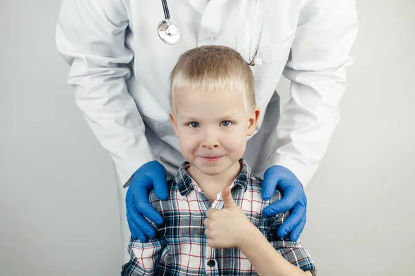 아이는 의사를 껴안는다 소아과 의사가 소년을 진찰하였다 서비스 배경에 — 스톡 사진