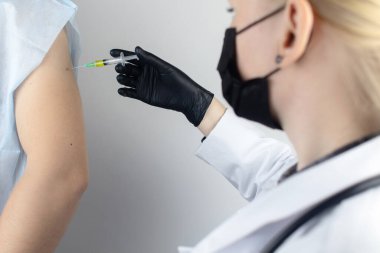 Bulaşıcı hastalıklar doktoru hastaya omzundan aşı yapıyor. Tetanos, grip, dizanteri, boğmaca, difteri, kızamık, şigelloz ve hepatit B 'ye karşı bağışıklık.