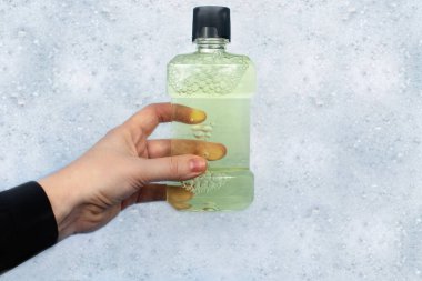 Deterjan şişeleri köpükte yüzer. Evdeki kimyasalların tehlikeleri kavramı. Bileşikteki sodyum, paraben, sülfat ve diğer kimyasal bileşiklerin ödüllendirilmesi. Bir konteynırda gargara.