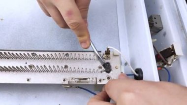 Elektrikli bir tamirci konvoycuyu tamir eder. Açık bir ısıtıcının ve iç kısmının yakın çekimi. Teknik yardım kavramı