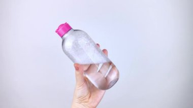 Sabunlu suda yüzen bir şişe mikiler suyu. Malzemelerin zararlı bileşimi. Gliserinle temizleyici. Kozmetik ve ev kimyasallarında tehlikeli maddeler kavramı