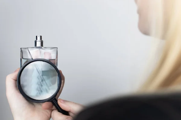 Una Mujer Examina Los Ingredientes Dañinos Del Perfume Través Una — Foto de Stock