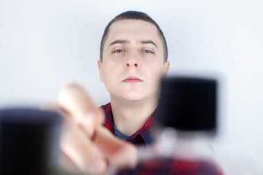 Tuvalette ağız gargarası kullanan bir adamın yakın çekimi. Diş bakımı konsepti. Dişlerini fırçaladıktan sonra prosedür. Antibakteriyel ağız sıvısı. Döküyor, duruluyor ve tükürüyor. Adam aynaya bak.