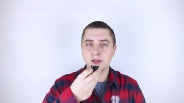 Tuvalette ağız gargarası kullanan bir adamın yakın çekimi. Diş bakımı konsepti. Dişlerini fırçaladıktan sonra prosedür. Antibakteriyel ağız sıvısı. Döküyor, duruluyor ve tükürüyor. Adam aynaya bak.