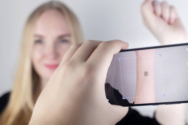 Kadın, adamın eline özel bir cihaz tarafından okunan ya da taranan bir çip yerleştirilmiş. Elektronik teknolojilerin çiplenmesi ve yerleştirilmesi kavramı. Sibernetik ve nanofüre. Siber Punk