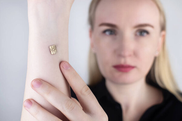 Женщина показывает свою руку с имплантированным чипом. Концепция чипирования и имплантации электронных технологий в человеческий организм. Кибернетика и нанотехнология. Рэппанк