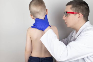 Doktor randevusunda sırt ağrısı olan küçük bir çocuk. Omurga deformasyonu ve boyun eğme tedavisi. Kemik erimesi, kifoz, lordosis veya skolyoz..