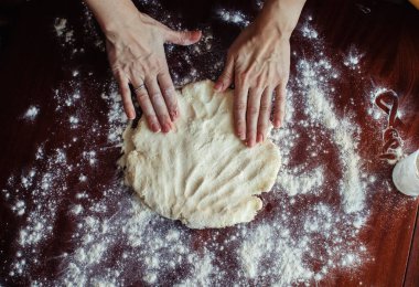 Mutfakta bir kadın ev yapımı hamur yapar. Kendini izole etme ya da karantina sırasındaki dersler. Eller ve un yakın çekim. Kurabiye ya da pizza. Ev konforu ve yemek konsepti.