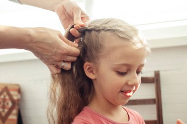 Annem kızının saçını tarıyor. Bebeğin saçına bakıyorum. Mutlu bir çocukluk ve çocuklara karşı iyi bir tutum. Mutlu aile