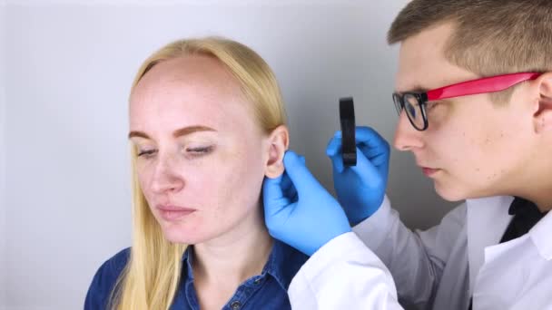 整形外科医は患者の耳を検査する 医者は耳のカールに結核があるのを見た ダーウィンの結核 — ストック動画