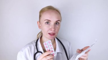 Beyaz arka plandaki doktor ilaçların talimatlarını okur. Uzman listeye ve ilacın bileşimine bakıyor. Profesyonel tedavi randevusu kavramı,