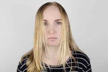 Kız yağlı saçlarına aynanın karşısına bakıyor. Sorunlu kafa derisi ve yağlı bezlerde artan salgı. Saç bakımı. Yağlı saç bakımı ve tedavi konsepti