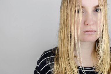 Kız yağlı saçlarına aynanın karşısına bakıyor. Sorunlu kafa derisi ve yağlı bezlerde artan salgı. Saç bakımı. Yağlı saç bakımı ve tedavi konsepti