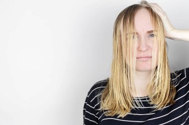 Kız yağlı saçlarına aynanın karşısına bakıyor. Sorunlu kafa derisi ve yağlı bezlerde artan salgı. Saç bakımı. Yağlı saç bakımı ve tedavi konsepti