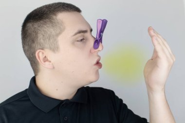 Nefesi kokan bir adam kameraya bakar. Kötü kokulu konsept. Ağzından pis bir koku duyan birinin yakın çekimi. Mide sorunları, ağız temizliği, tütün kokusu, diyet yan etkileri.