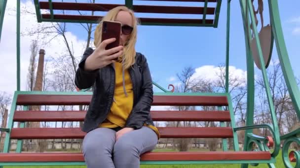 Het Meisje Maakt Een Selfie Het Park Terwijl Een Schommel — Stockvideo