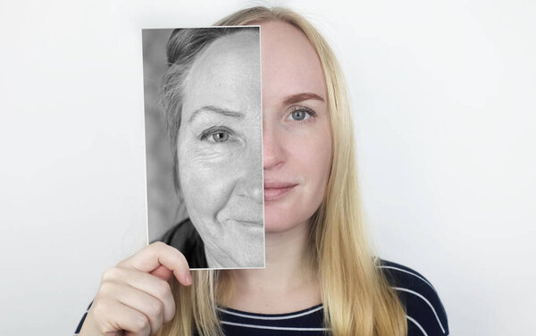 Девушка держит фотографию своей старой матери лицом к лицу. Старение, генетика, семейное древо и потеря молодежной концепции. До и после возрастных изменений.