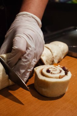 Bir pasta şefi puf böreği üzerine şekerli meyve, kuru üzüm ve çikolata parçaları yayar. Kıvırcık hamurlar. Pasta şefliği işi. Tatlılar yapılıyor