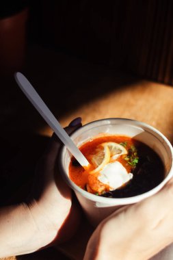 Tek kullanımlık kağıt bardaktaki bir balyozun yakın çekimi. Geleneksel yemek ve yabancı mutfak kavramı. Güvenli çevre dostu tek kullanımlık sofra takımı.