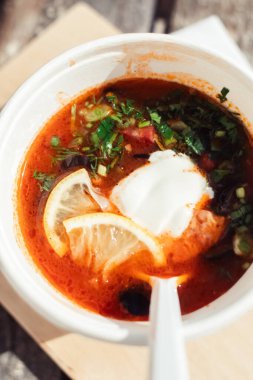 Tek kullanımlık kağıt bardaktaki bir balyozun yakın çekimi. Geleneksel yemek ve yabancı mutfak kavramı. Güvenli çevre dostu tek kullanımlık sofra takımı.