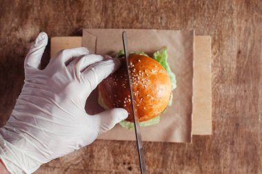 Mini burger tezgahta yakın planda. Lokantada ya da kafede çocuklar hazır yemek yer. Et ve sebzeli hamburger malzemelerinin Macro fotoğrafı. Çocuklar için eko-burger
