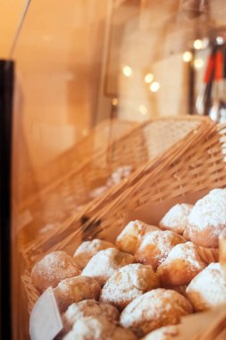 Tepside yakın plan muffinler. Pudra şekerli kek. Şekerleme endüstrisinin işi. Her kek kâğıt ambalaja sarılmış. Dikey fotoğraf