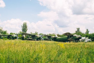 Devre dışı bırakılmış ve turistleri temsil eden eski bir yolcu uçağının yakın çekimi. Uçağın gövdesinde pas ve çip izleri var. Metal yapının bazı kısımları kanatlarda görünür.