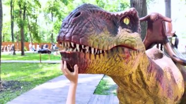 A close-up of a full-length mini Tyrannosaurus Rex. Reconstruction of extinct species. Swing for children. Styling extinct animals. Dinosaurs robots, animatronics and robotics
