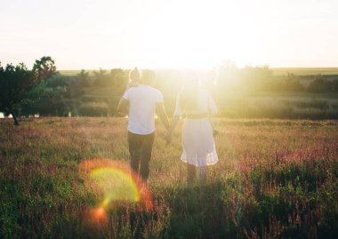 Lavanta tarlasının ortasında bir aile. Anne, baba ve iki kız bozkırda piknik yaptılar. Doğada mutlu bir aile. Yaşam tarzı ve keyifli vakit geçirme konsepti. Gün batımı ışınlarında bilge. Piknik
