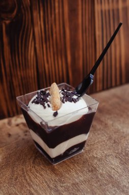 Çok renkli katmanlı dondurmanın yakın çekimi. Yaratıcı yiyecekler. Vejetaryen tatlıları. Lokantada ya da kafede bir bardakta tatlı. Soya sütü, çikolata ve meyveler güzel bir tabakta.