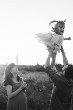 Baba ve kızı hamile bir kadına bakıyor. Aile ikinci bir çocuk bekliyor. Küçük kız kardeşi erkek kardeşini bekliyor. Sevgi dolu akrabalar hamile karnını öper ve okşarlar.