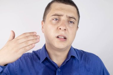 Mavi gömlekli bir ofis çalışanı kameraya bakar. Ter lekesiyle kaplıydı. Adamın çok fazla stresi var ve yanında terlemesi de var. İş adamı gergin ve çok terliyor..