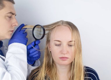 Bir trichologist yağlı saçlı bir kızı muayene ediyor. Sorunlu kafa derisi ve yağlı bezlerde artan salgı. Saç bakımı. Yağlı saç bakımı ve tedavi konsepti. Doktor tedavi öneriyor..