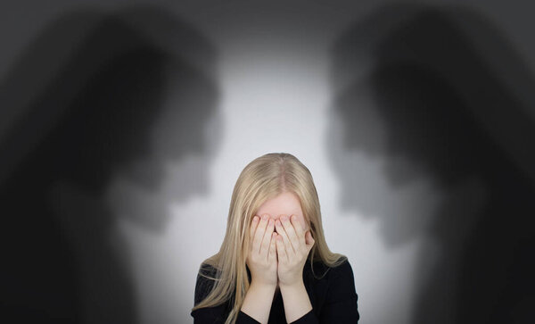 The woman is experiencing a panic attack. The concept of phobia, fears, paranoia and persecution mania. Shadow silhouettes surrounded the man. Nervous breakdown and nervous disorders